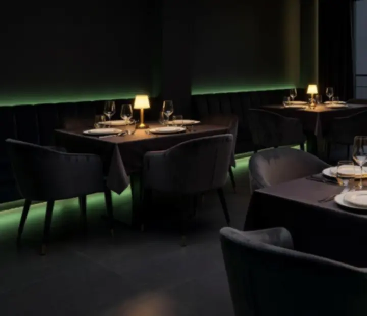 Atmosféra soukromé večeře v restauraci Gather Housse s tlumeným osvětlením a elegantně prostřenými stoly.